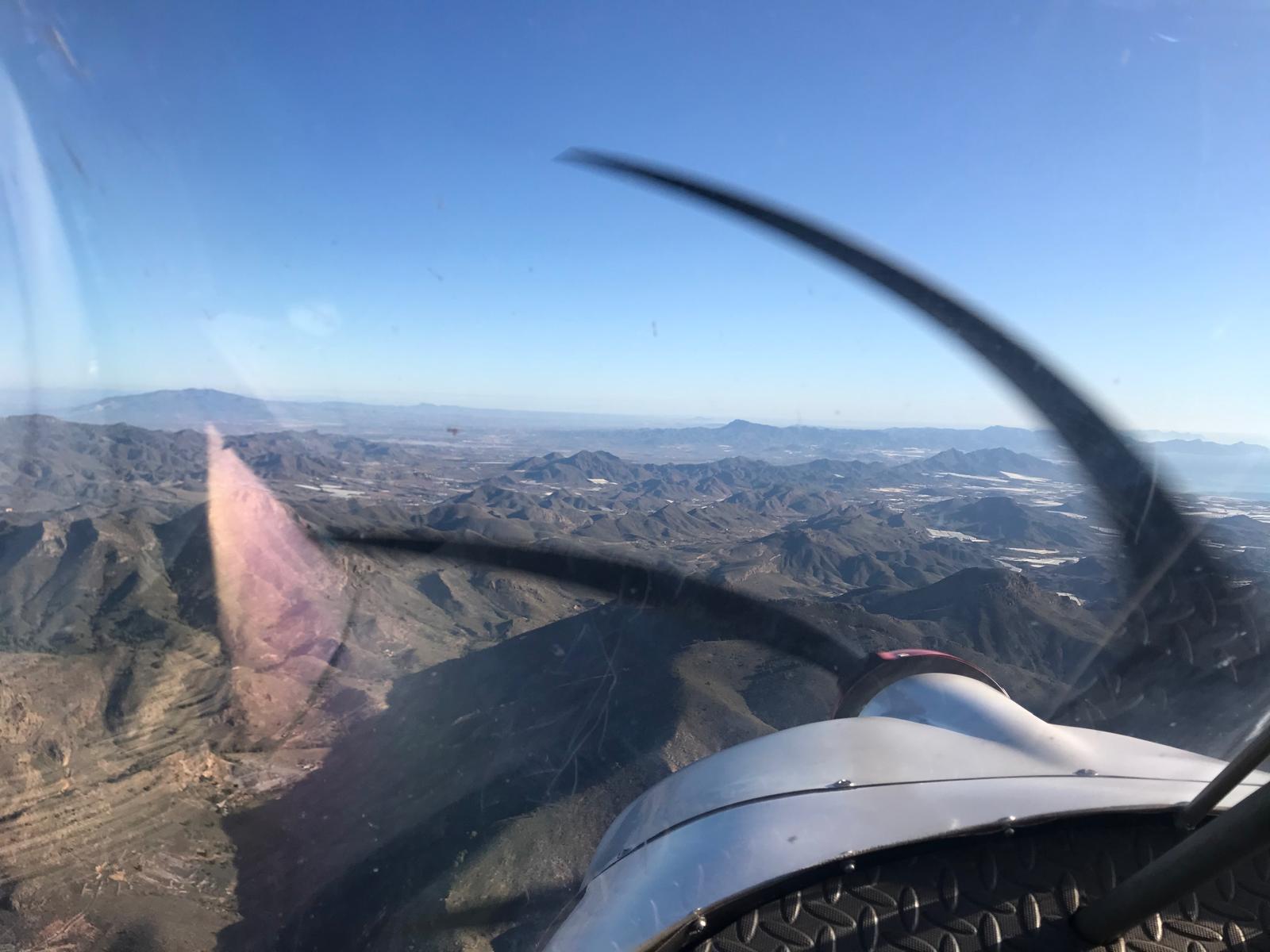 Propeller view over mountains from a light aircraft